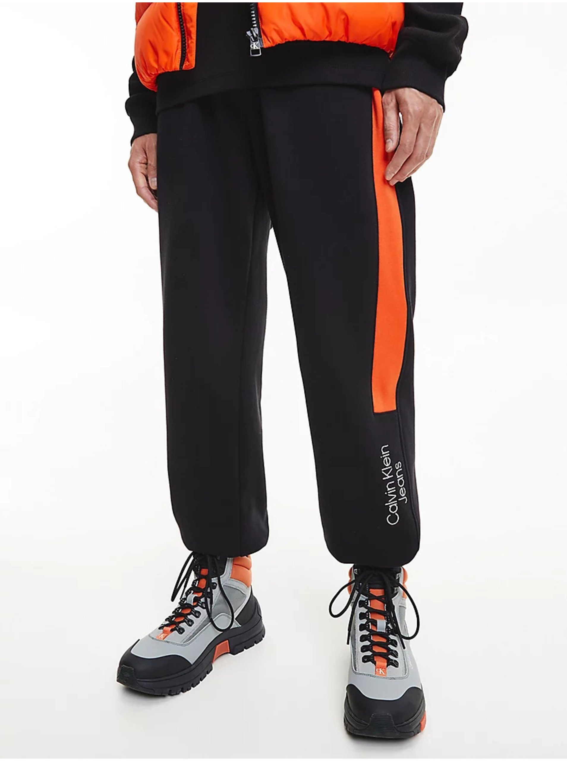 Levně Oranžovo-černé pánské tepláky Calvin Klein Jeans