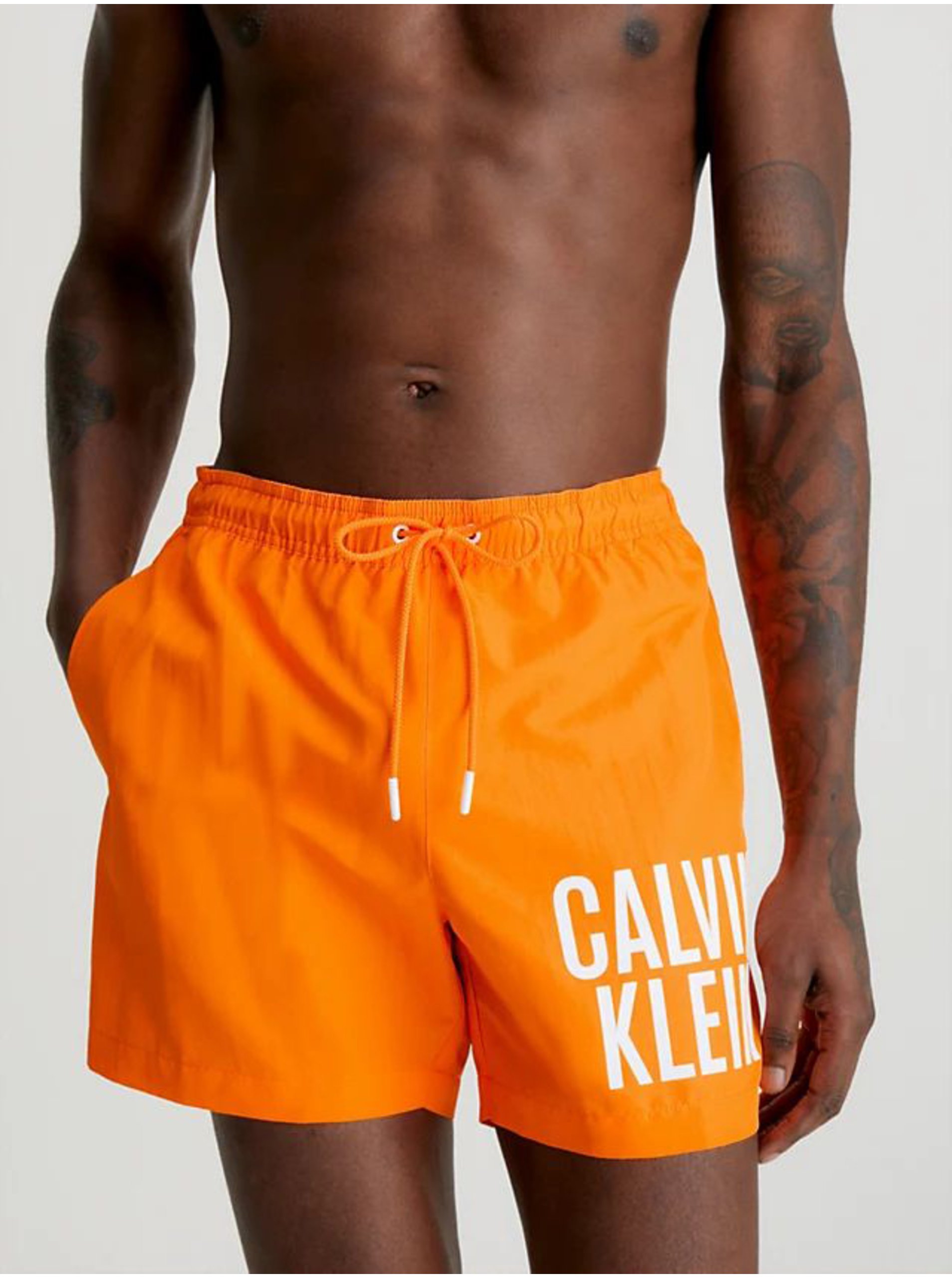 Levně Oranžové pánské plavky Calvin Klein Underwear